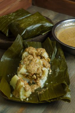 Lontong oncom, muz yapraklarına sarılmış pirinç kekleri ile geleneksel Endonezya yemeği, baharatlı fıstık sosuyla servis edilir..