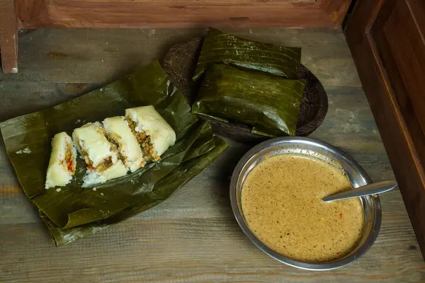 stock image Lontong oncom, a traditional Indonesian dish with steamed rice cakes wrapped in banana leaves, served with spicy peanut sauce.