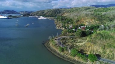 Sekotong, Lombok, Endonezya yakınlarındaki hava manzaralı bir yol, yemyeşil, dolambaçlı bir yol ve dramatik bir uçurum yüzeyi var..
