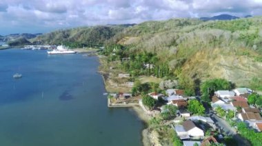 Sekotong, Lombok, Endonezya yakınlarındaki hava manzaralı bir yol, yemyeşil, dolambaçlı bir yol ve dramatik bir uçurum yüzeyi var..