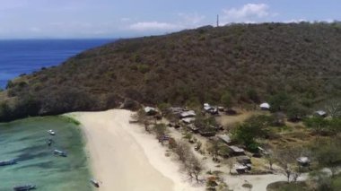 Pantai Tangsi, Lombok, Endonezya 'nın hava manzarasında el değmemiş beyaz kum, kristal berrak turkuaz su ve yemyeşil tepeler sergileniyor..