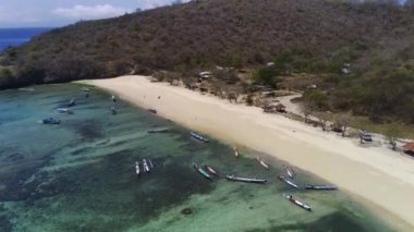 Pantai Tangsi, Lombok, Endonezya 'nın hava manzarasında el değmemiş beyaz kum, kristal berrak turkuaz su ve yemyeşil tepeler sergileniyor..