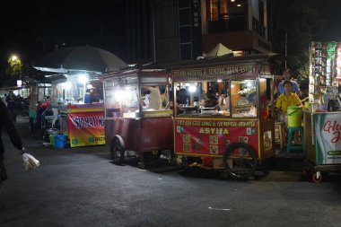 14 Ağustos 2024. Jakarta, Endonezya. Şehrin bir köşesinde hareketli bir gece sahnesi, sokak satıcıları ve müşterilerle dolu..