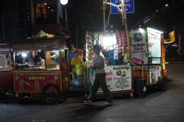 14 Ağustos 2024. Jakarta, Endonezya. Şehrin bir köşesinde hareketli bir gece sahnesi, sokak satıcıları ve müşterilerle dolu..