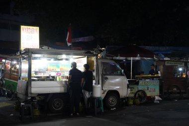 14 Ağustos 2024. Jakarta, Endonezya. Şehrin bir köşesinde hareketli bir gece sahnesi, sokak satıcıları ve müşterilerle dolu..