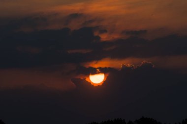 Soluk kesen bir günbatımı, Endonezya 'nın sakin sularını yansıtan ve uzun gölgeler oluşturan sakin Surabaya sulak arazisinin üzerinde ateşli turuncu renklerle gökyüzünü boyar..