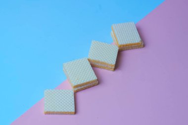 Mavi ve pembe arkaplanlı sarı gofret yığını. Boşluğu kopyala