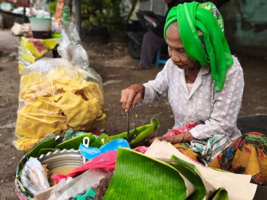 23 Ekim 2024. Surabaya, Endonezya 'daki bir sokak satıcısı, geleneksel bir Endonezya salatası olan Pecel Semanggi' yi satıyor..