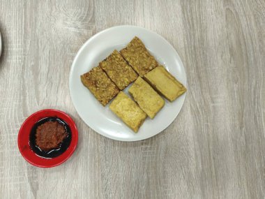 Bir tabak kızarmış tempeh ve tofu, popüler bir Endonezya yemeği. Geleneksel acı biber ezmesiyle beyaz bir tabakta servis edilir..