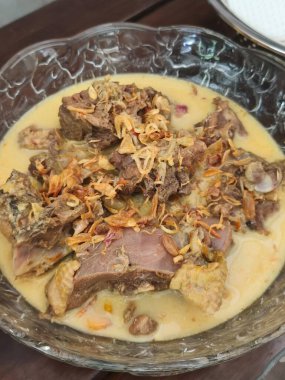 Bu, güzel sunulmuş bir kâse lezzetli yemeğin yakın plan görüntüsü. Bir masada oturuyor ve etrafındaki herkesi aromasıyla baştan çıkarıyor.