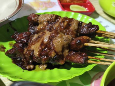 Bir tabak sulu Sate Kambing ya da fıstık soslu keçi satay, yenmeye hazır. Bu Endonezya 'dan..