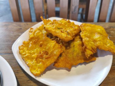 Altın sarısı Tempe Mendoan, soya fasulyesinden yapılan çıtır bir Endonezya aperatifi, baharatlı sosla servis edilir..