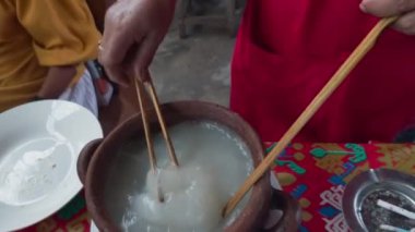 Papeda, Endonezya 'nın geleneksel sago lapası lezzetli sarı balık çorbasıyla servis edilir, otlar ve biberlerle süslenir..