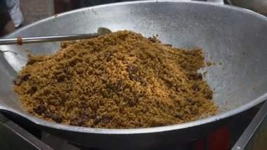 Taze pişmiş Nasi Goreng Kambing ile dolu büyük bir tava, Endonezya 'nın ikonik kızarmış pirinci, baharatlı ve etle süslenmiş.