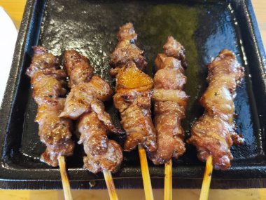 Baharatlı keçi eti şişi ya da sıcak bir tabakta satay yanında taze sebze ve sosla birlikte..