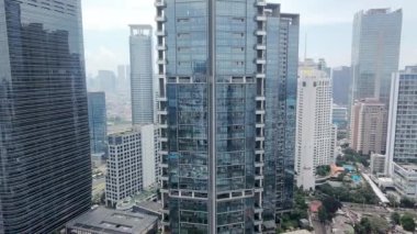 3 Ocak 2025. Jakarta, Endonezya. Zarif bir insansız hava aracı Jakarta 'nın beton ormanında, heybetli gökdelenler arasında süzülüyor. Kuş bakışı bakış açısı harika..