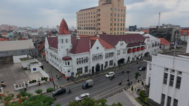 January 4, 2025. Aerial view of a bustling street in Surabaya, Indonesia showcasing an old town mix of traditional and modern architecture, with a prominent row of buildings. clipart