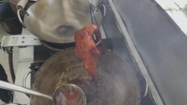 Pekin ördeğini tavadan çıkan kızgın yağın içine batırıp deriyi inanılmaz derecede çıtır çıtır yapan dumanlı bir manzara yaratma süreci..