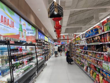 5 Ocak 2025. Surabaya, Endonezya. Lunar Yeni Yıl dekorasyonlarıyla süslenmiş hareketli bir süpermarket. Müşteriler koridorlarda geziniyor..