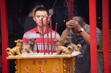 January 19, 2025. Tangerang, Indonesia. The festive atmosphere leading up to Chinese New Year at a temple in Tangerang, Indonesia. Worshippers pray, while red lanterns and candles adorn the temple. clipart