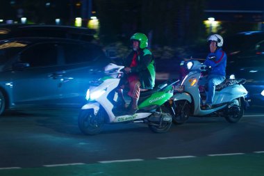 January 24, 2025, in Jakarta, Indonesia, the bustling night city was characterized by a traffic jam on MH Thamrin Road near the HI roundabout, with motorcycles and cars jostling for position. clipart