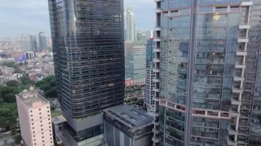 16 Ocak 2025. Jakarta, Endonezya. Jenderal Sudirman Caddesi 'ndeki yüksek binaların arasında uçan insansız hava aracı..