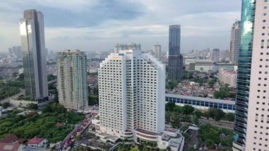 16 Ocak 2025. Jakarta, Endonezya. Jenderal Sudirman Caddesi 'ndeki yüksek binaların arasında uçan insansız hava aracı..