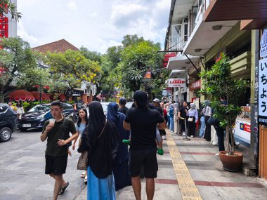 29 Ocak 2025. Bandung, Endonezya. Jalan Braga 'da canlı bir sahne, trafik ve yayalarla dolu, Çin Yeni Yıl kutlamalarının neşeli atmosferinde renkli bir tur otobüsünün yer aldığı.