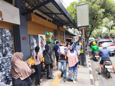 29 Ocak 2025. Bandung, Endonezya. Jalan Braga 'da canlı bir sahne, trafik ve yayalarla dolu, Çin Yeni Yıl kutlamalarının neşeli atmosferinde renkli bir tur otobüsünün yer aldığı.