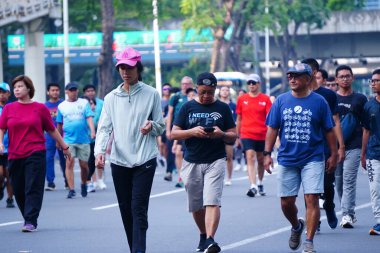 16 Şubat 2025. Jakarta, Endonezya. Jalan Sudirman 'ın Arabasız Günü' nden canlı bir sahne, çeşitli katılımcılar renkli atletizm kıyafetleriyle koşuyor ve temiz havanın tadını çıkarıyor..