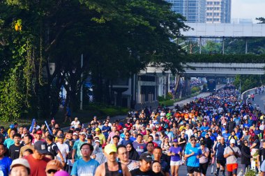 16 Şubat 2025. Jakarta, Endonezya. Jalan Sudirman 'ın Arabasız Günü' nden canlı bir sahne, çeşitli katılımcılar renkli atletizm kıyafetleriyle koşuyor ve temiz havanın tadını çıkarıyor..