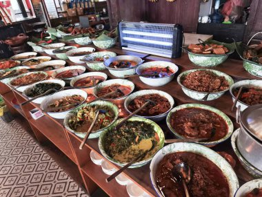 Geleneksel kâselerde çeşitli Endonezya yemeklerinin canlı bir yayılımı.