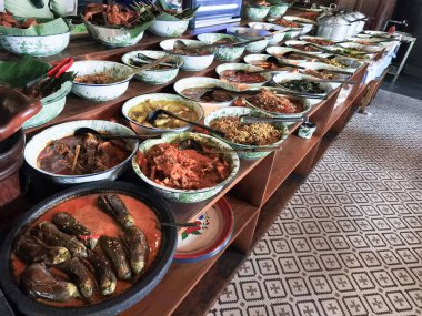 Geleneksel kâselerde çeşitli Endonezya yemeklerinin canlı bir yayılımı.