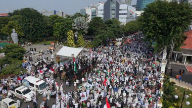 19 Nisan 2025. Surabaya, Endonezya. Kırmızı, beyaz, yeşil ve siyah bayraklar taşıyan kalabalık bir kalabalıkla Filistin Özgürlüğü için düzenlenen büyük şehir gösterisinin havadan görüntüsü. Hoparlörlerin ve ambulansların olduğu bir sahne..