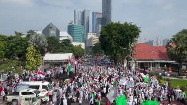 19 Nisan 2025. Surabaya, Endonezya. Kırmızı, beyaz, yeşil ve siyah bayraklar taşıyan kalabalık bir kalabalıkla Filistin Özgürlüğü için düzenlenen büyük şehir gösterisinin havadan görüntüsü. Hoparlörlerin ve ambulansların olduğu bir sahne.