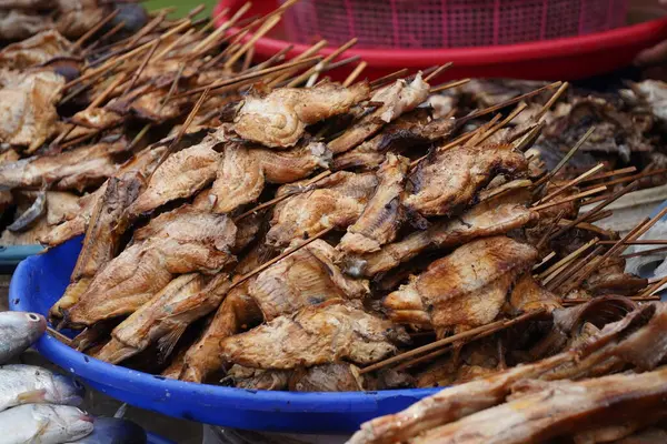 Bir sepete doldurulmuş füme balık. Pazarda satılmaya hazır. Popüler bir sokak yemeği veya yerel bir lezzet sergiliyor..