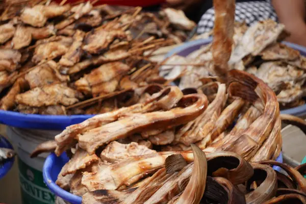 Bir sepete doldurulmuş füme balık. Pazarda satılmaya hazır. Popüler bir sokak yemeği veya yerel bir lezzet sergiliyor..