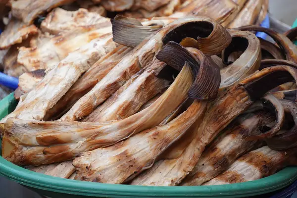 Bir sepete doldurulmuş füme balık. Pazarda satılmaya hazır. Popüler bir sokak yemeği veya yerel bir lezzet sergiliyor..
