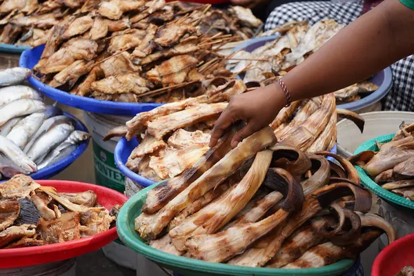 Bir sepete doldurulmuş füme balık. Pazarda satılmaya hazır. Popüler bir sokak yemeği veya yerel bir lezzet sergiliyor..