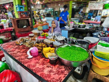 31 Mayıs 2025. Blauran Market, Surabaya, Endonezya 'da renkli malzemeler, paslanmaz kaseler ve gündelik oturma yerleri içeren çeşitli yerel yemekler sunan canlı bir geleneksel market tezgahı..