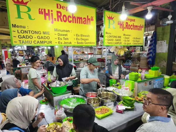 31 Mayıs 2025. Blauran Market, Surabaya, Endonezya 'da renkli malzemeler, paslanmaz kaseler ve gündelik oturma yerleri içeren çeşitli yerel yemekler sunan canlı bir geleneksel market tezgahı..