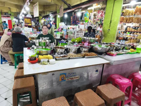 31 Mayıs 2025. Blauran Market, Surabaya, Endonezya 'da renkli malzemeler, paslanmaz kaseler ve gündelik oturma yerleri içeren çeşitli yerel yemekler sunan canlı bir geleneksel market tezgahı..