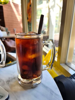 Lo Han Kuo ya da Monk Fruit İçeceği, koyu kehribar rengi ve kaşık, güneşli bir pencere tarafından hazırlanmış buzlu bir içecek..