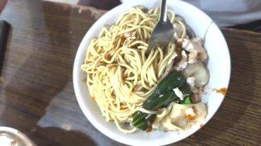 Tadını çıkarmadan önce bir kase tavuk eriştesi karıştırılıyor, sambal, lezzetli hamur tatlısı ve tavuk parçaları ile..