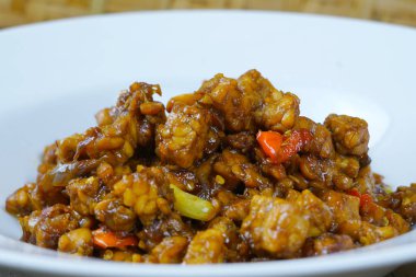 Soya soslu, acılı ve diğer baharatlı beyaz Endonezya usulü kızarmış tempeh..