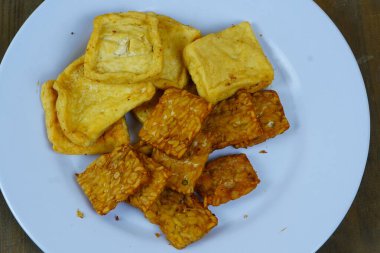 Bir tabak Endonezya usulü kızarmış abur cubur, altın sarısı soya peyniri ve kızarmış tempeh dahil, popüler yerel mezeler sergileniyor..