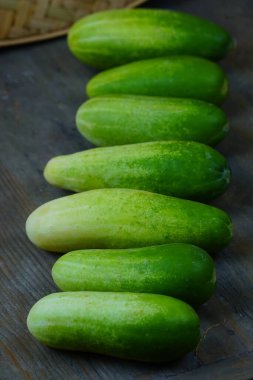 Köy ahşap bir yüzeye serilmiş taze, yeşil salatalıktan oluşan yatay bir çizgi..