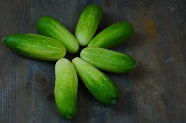 Köy ahşap bir yüzeye serilmiş taze, yeşil salatalıktan oluşan yatay bir çizgi..