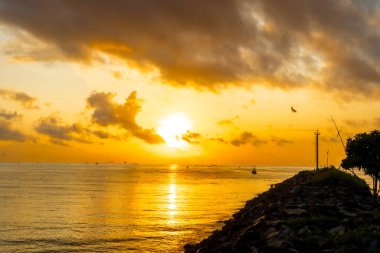 Sakin şafak deniz manzarası. Denizin üzerinde güzel bir gün doğumu, geleneksel balıkçı teknelerinin ilk ışığa yetişmesi..