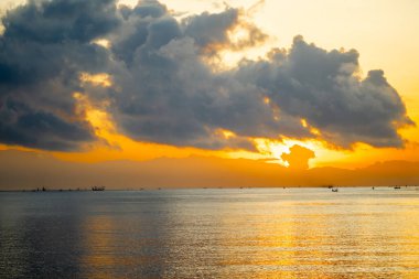 Sakin şafak deniz manzarası. Denizin üzerinde güzel bir gün doğumu, geleneksel balıkçı teknelerinin ilk ışığa yetişmesi..